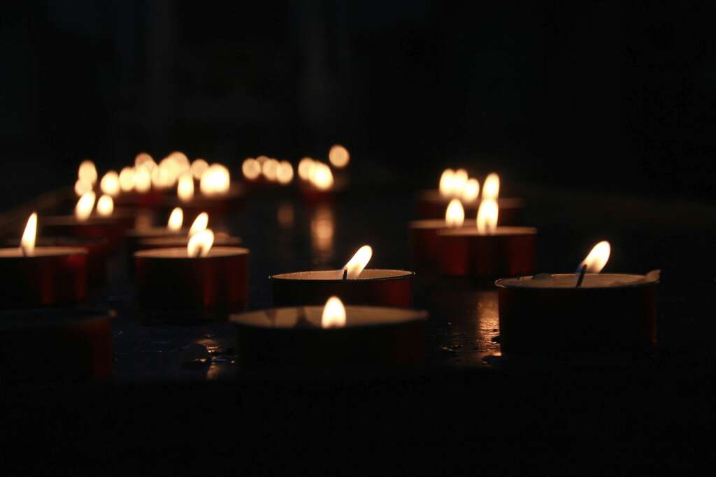 many lit tealights in the dark